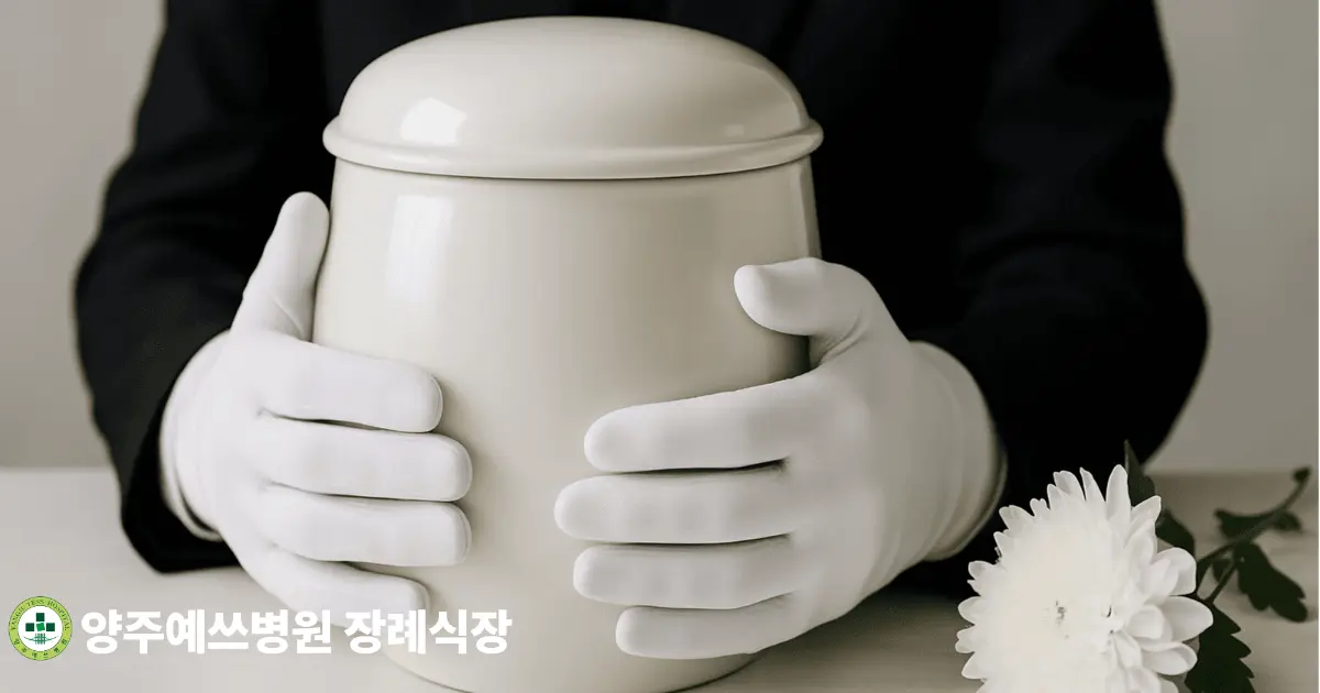 두 손으로 흰 유골함을 들고 있는 모습